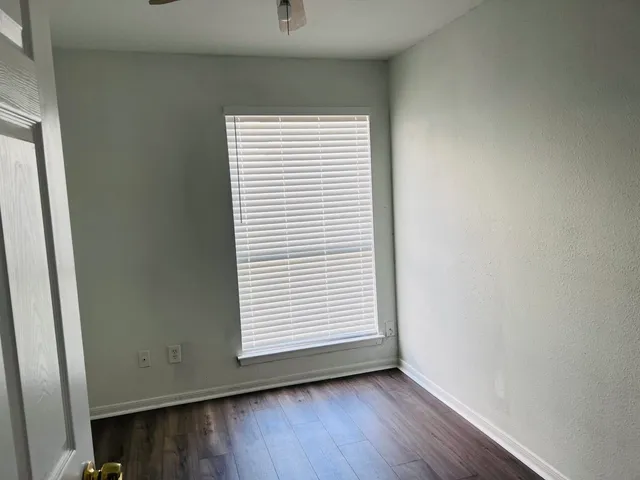 an empty room with wooden floor and a window