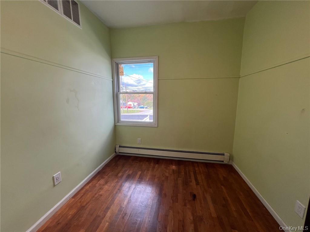 708 Silver Lake-Scotchtown Road Middletown, NY 10941 - Photo 20 of 25 Unfurnished room with dark wood-type flooring and a baseboard radiator