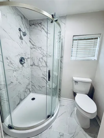 a bathroom with a toilet and shower