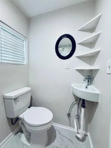 a bathroom with a toilet a sink and a mirror