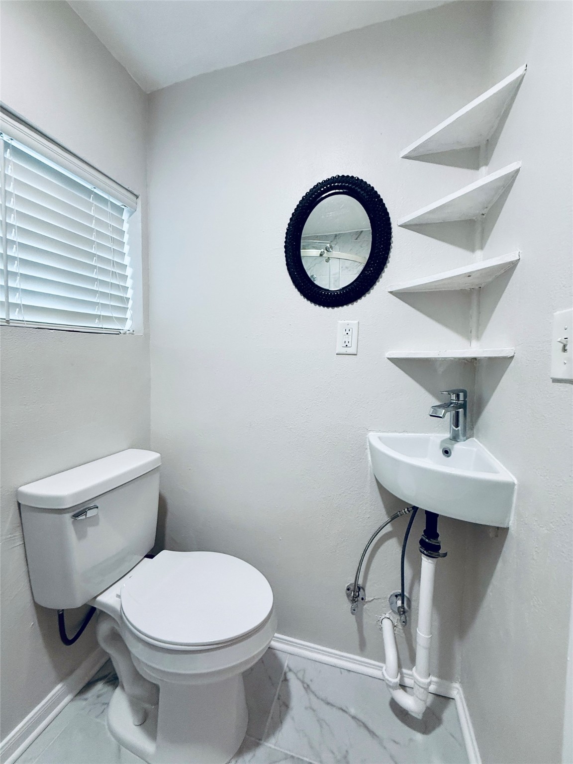 3921 Woodleigh Street, Unit 3 Houston, TX 77023 - Photo 5 of 6 a bathroom with a toilet a sink and a mirror