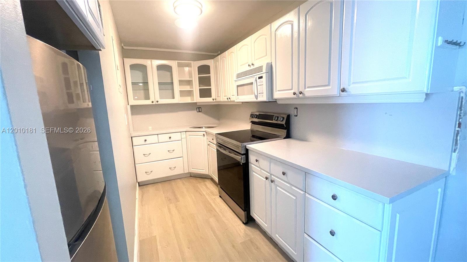 200 South Birch Road, Unit 604 Fort Lauderdale, FL 33316 - Photo 12 of 35 a kitchen with stainless steel appliances granite countertop a refrigerator a sink dishwasher and white cabinets with wooden floor