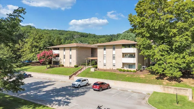 a front view of a house with a garden and trees