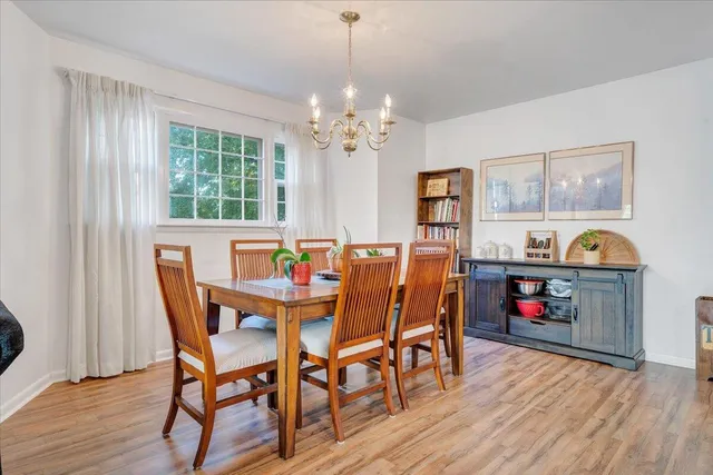 a view of a dining room with furniture wooden floor and chandelier