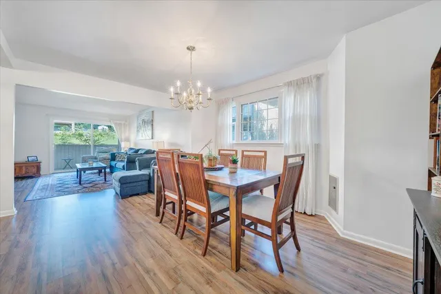 a view of a dining room with furniture a chandelier and wooden floor