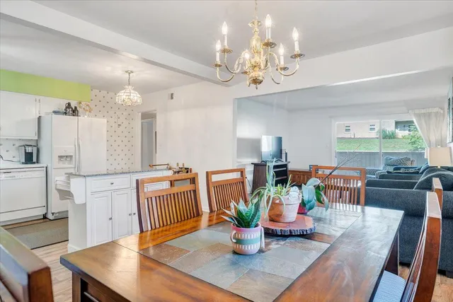 a view of a dining room with furniture a chandelier and wooden floor