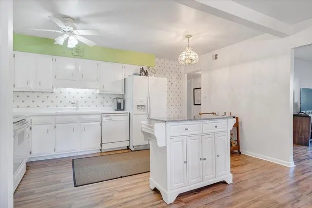 a kitchen with white cabinets and sink