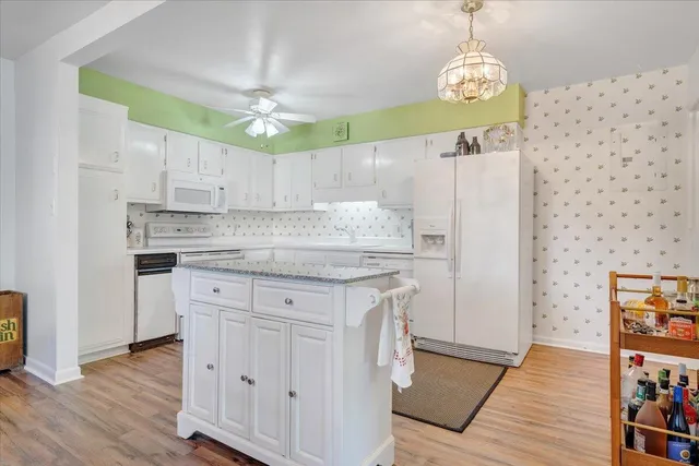 a kitchen with kitchen island granite countertop a sink a counter space and cabinets