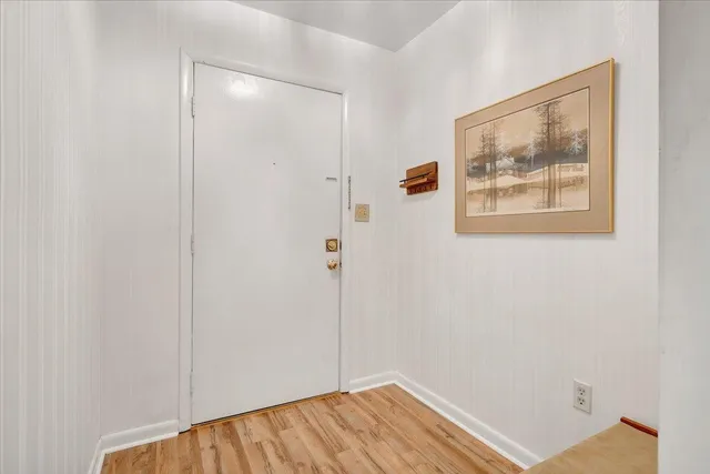 a view of a hallway with wooden floor and closet