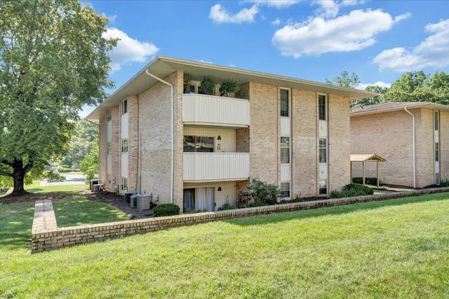 a front view of a house with a garden and trees