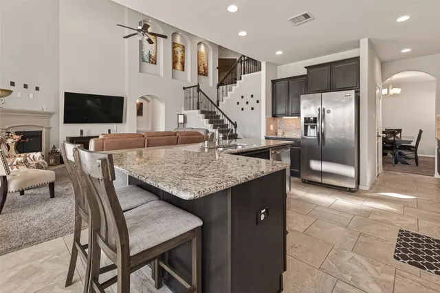 a kitchen with granite countertop kitchen island stainless steel appliances a table and chairs