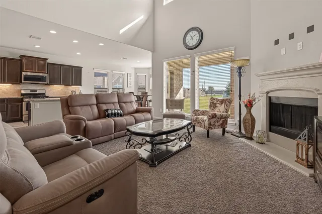 a living room with furniture a large window and a fireplace