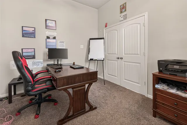 a view of a workspace with furniture and a window