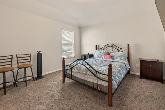 a bedroom with a bed chair and window