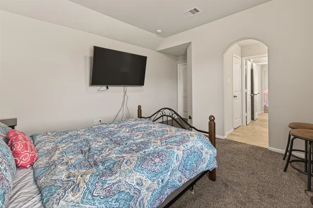 a bedroom with a bed and a flat screen tv