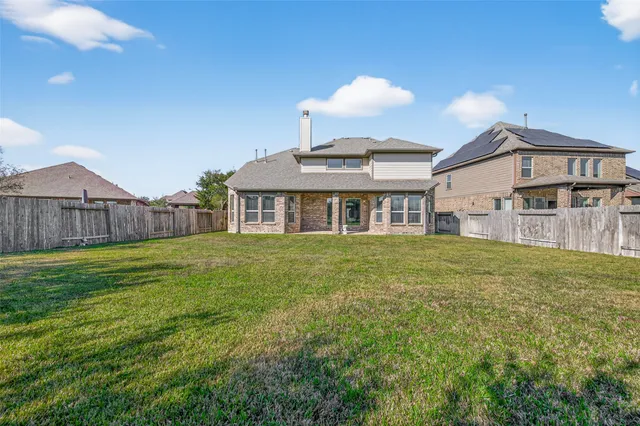 a front view of house with yard barbeque and outdoor seating