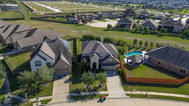 an aerial view of a house with a garden and lake view