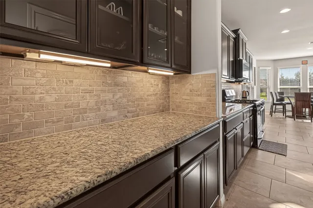 a kitchen with stainless steel appliances granite countertop a sink stove and cabinets