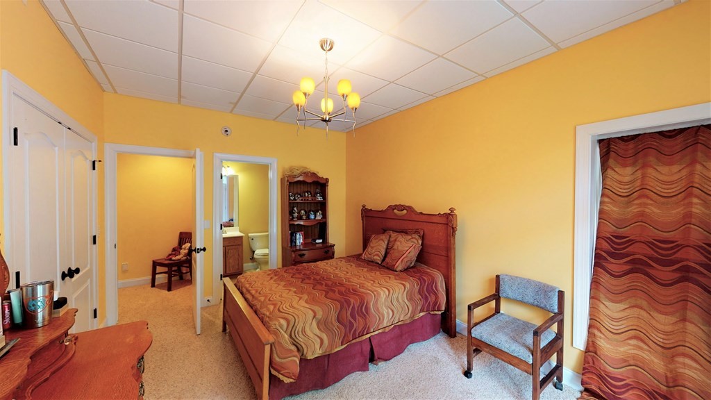 1153 Reynolds Bridge Road Benton, TN 37307 - Photo 44 of 70 a spacious bedroom with a bed and a chandelier