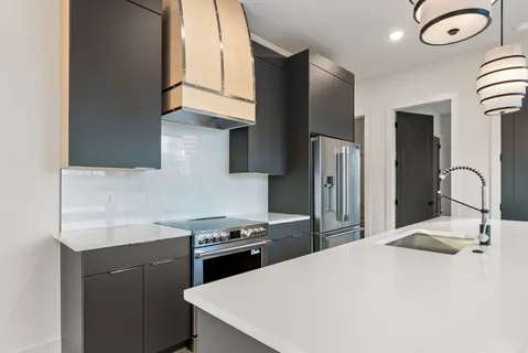 a large kitchen with stainless steel appliances kitchen island a large counter top and a wooden floors