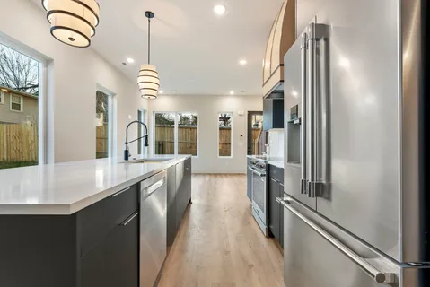 a kitchen with stainless steel appliances a refrigerator sink and stove