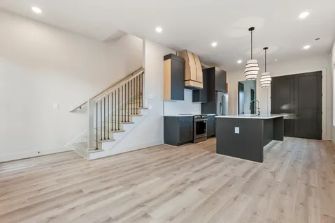 a large kitchen with stainless steel appliances kitchen island a large counter top and a wooden floors