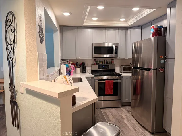 a metallic refrigerator freezer sitting inside of a kitchen