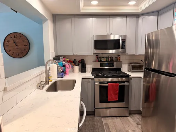 a kitchen with stainless steel appliances granite countertop a stove a sink and a refrigerator