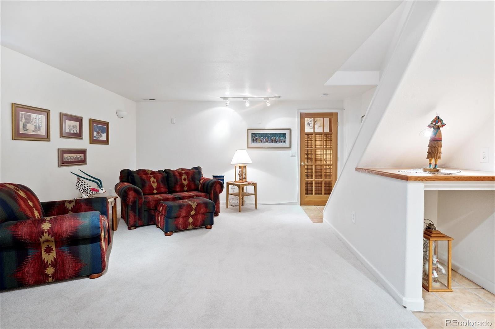 6381 Deframe Way Arvada, CO 80004 - Photo 11 of 22 a living room with furniture and a flat screen tv