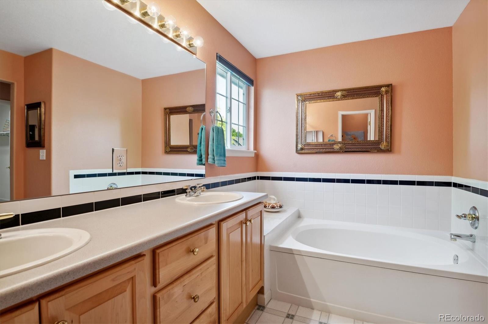 6381 Deframe Way Arvada, CO 80004 - Photo 17 of 22 a bathroom with a tub a sink and mirror