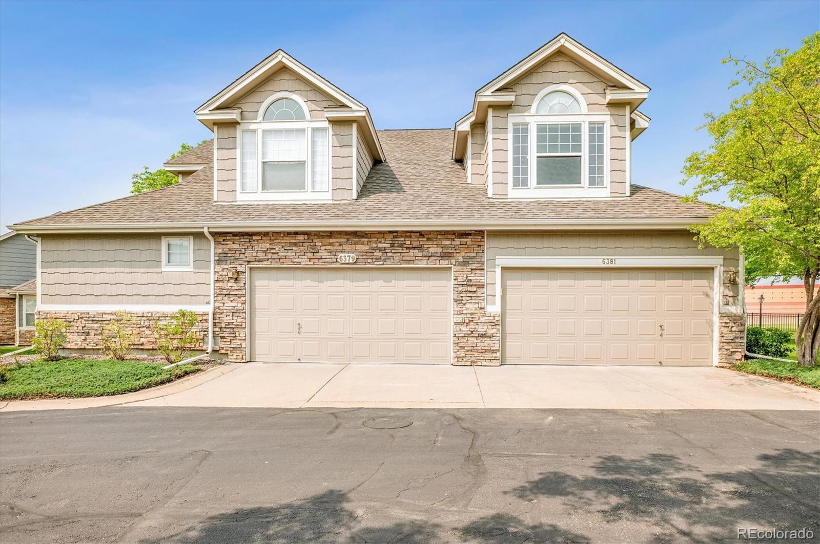 6381 Deframe Way Arvada, CO 80004 - Photo 2 of 22 a front view of a house with a yard and garage
