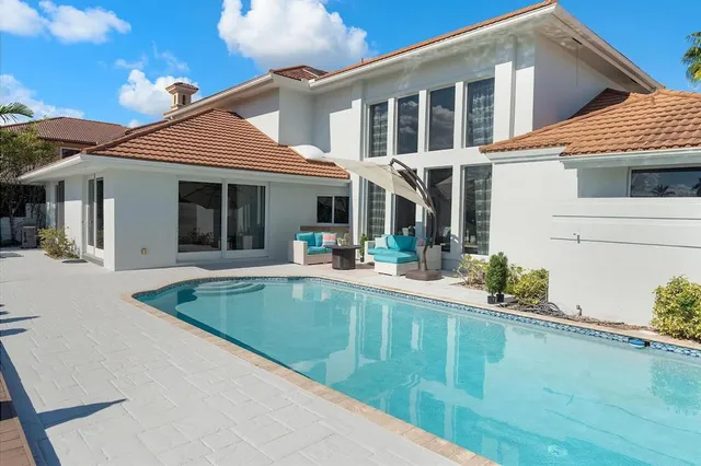 a view of a house with pool and chairs