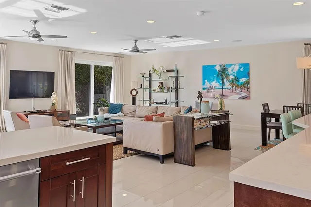 a living room with furniture kitchen view and a large window