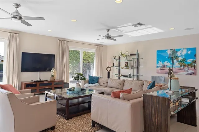 a living room with furniture flat screen tv and a large window