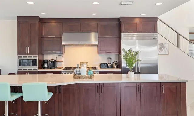 a living room with furniture kitchen view and a chandelier