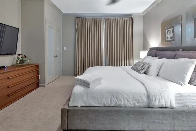 a spacious bedroom with a bed and flat screen tv