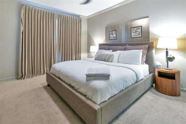 a spacious bedroom with a bed and a flat screen tv