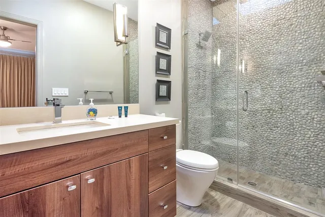 a bathroom with a sink a toilet and shower