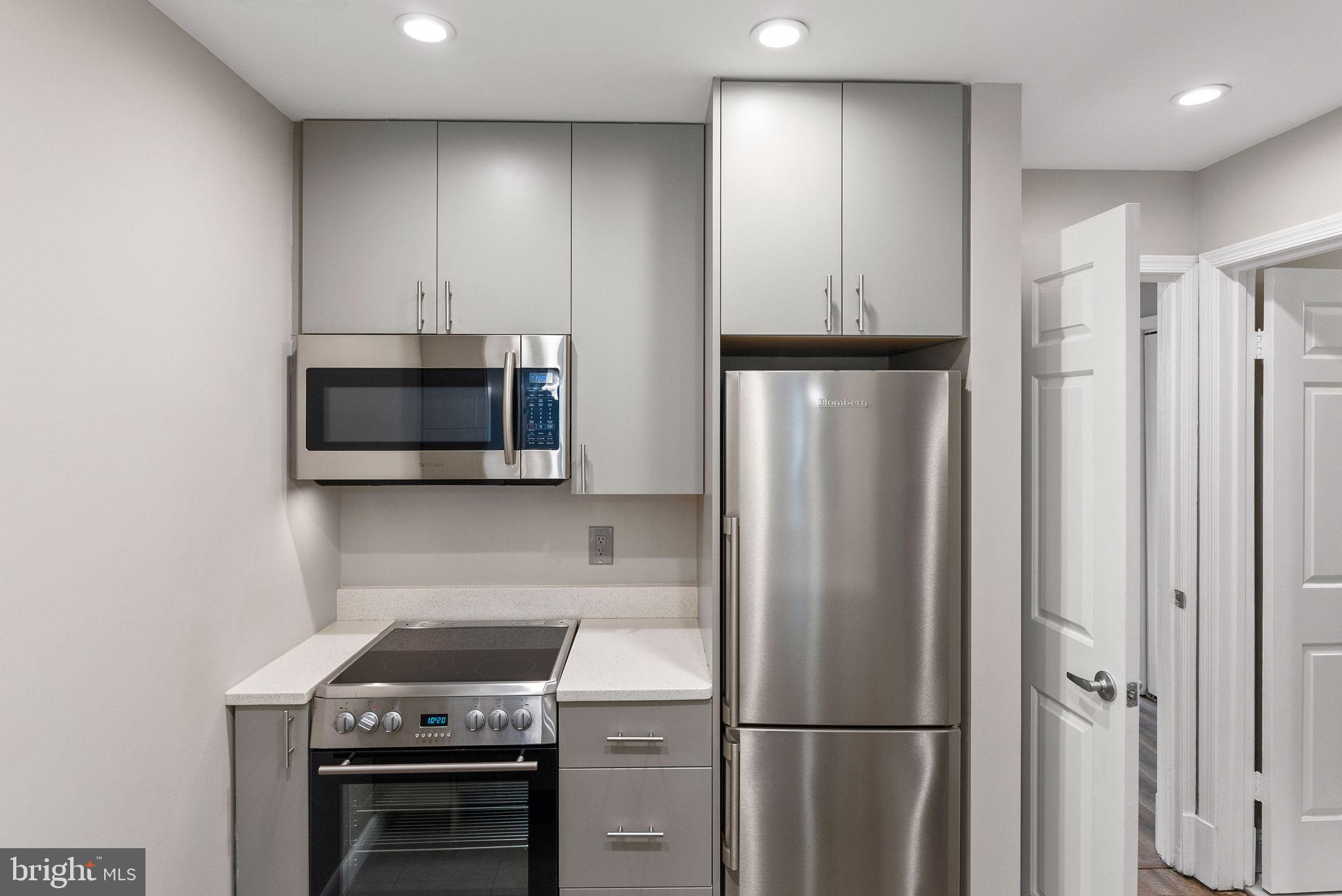 2011 Hillyer Place Northwest Washington, DC 20009 - Photo 16 of 21 a kitchen with white cabinets and stainless steel appliances
