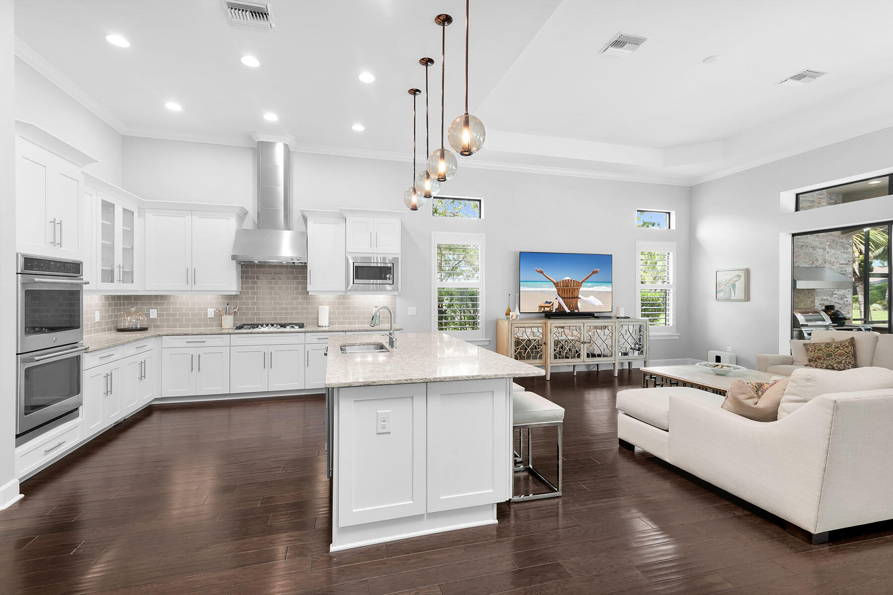 3193 Olympia Lane Naples, FL 34114 - Photo 12 of 50 a large kitchen with a lot of white cabinets a sink dishwasher and a stove with wooden floor