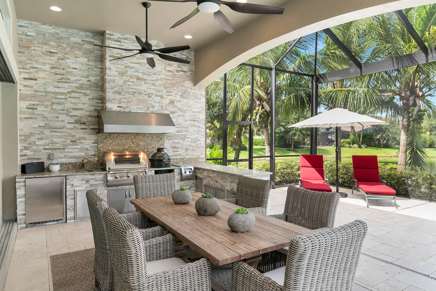 3193 Olympia Lane Naples, FL 34114 - Photo 30 of 50 a view of a patio with a dining table and chairs under an umbrella with a fire pit