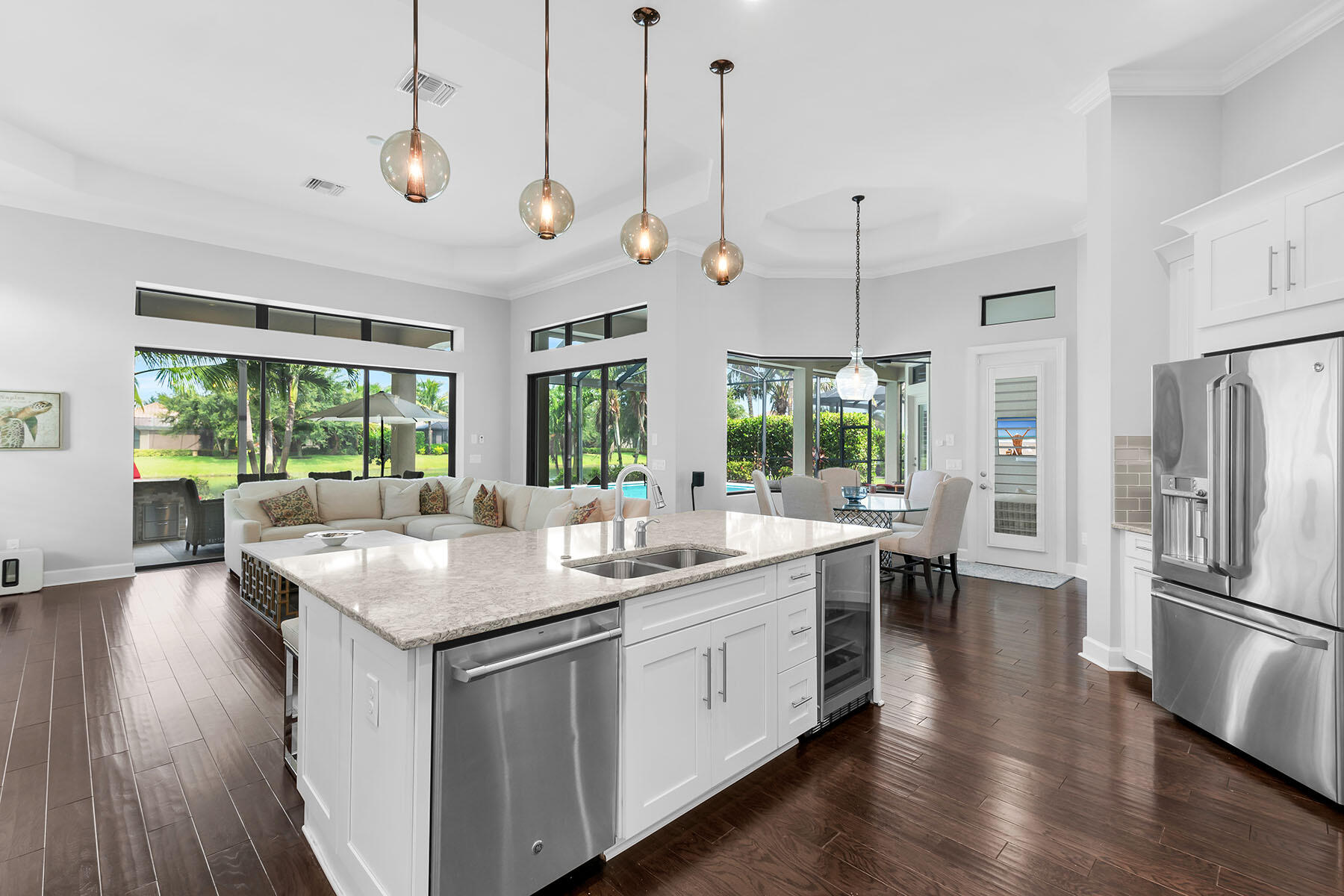 3193 Olympia Lane Naples, FL 34114 - Photo 10 of 50 a kitchen with kitchen island a sink and a wooden floor