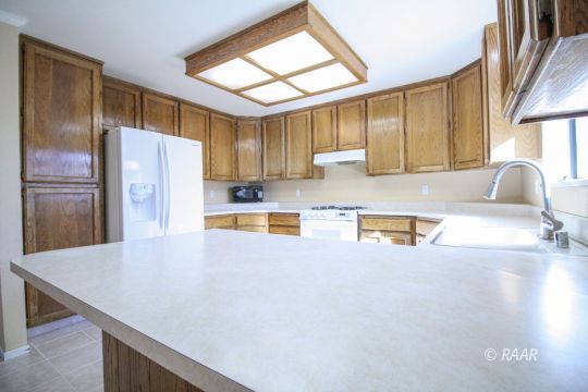 408 South Valley Street Ridgecrest, CA 93555 - Photo 9 of 29 a kitchen with stainless steel appliances a refrigerator and a sink