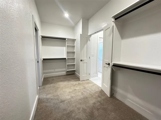 a hallway view with stainless steel appliances granite countertop a sink and a refrigerator