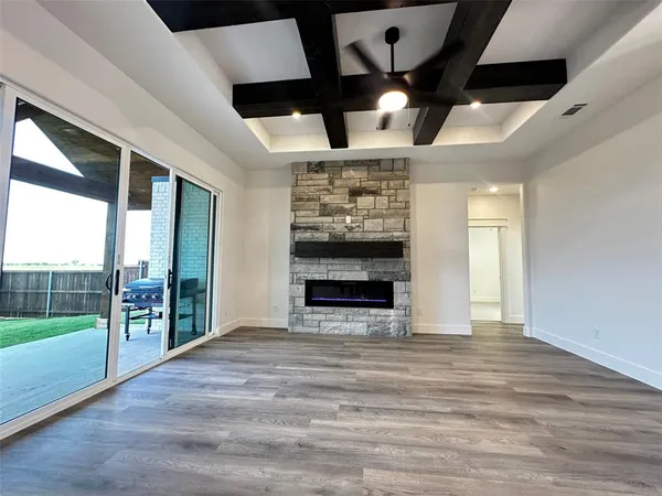 en empty room with windows and ceiling fan