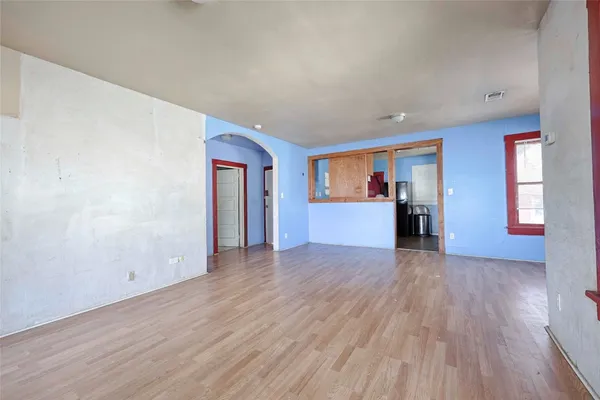 a view of empty room with wooden floor and window