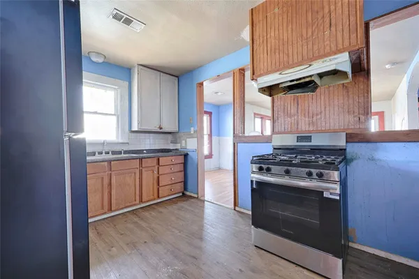 a kitchen with stainless steel appliances granite countertop a stove a sink and a refrigerator