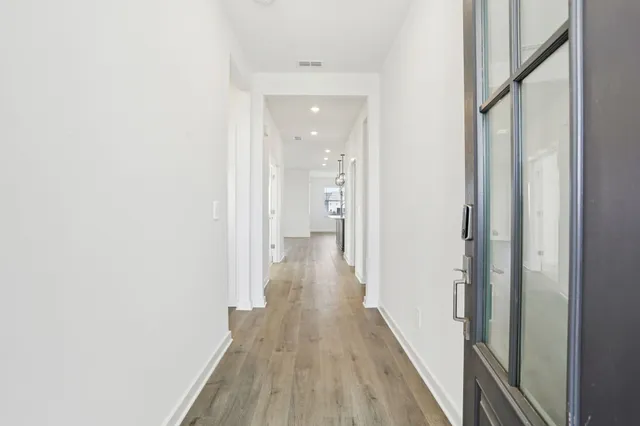 a view of a hallway with wooden floor