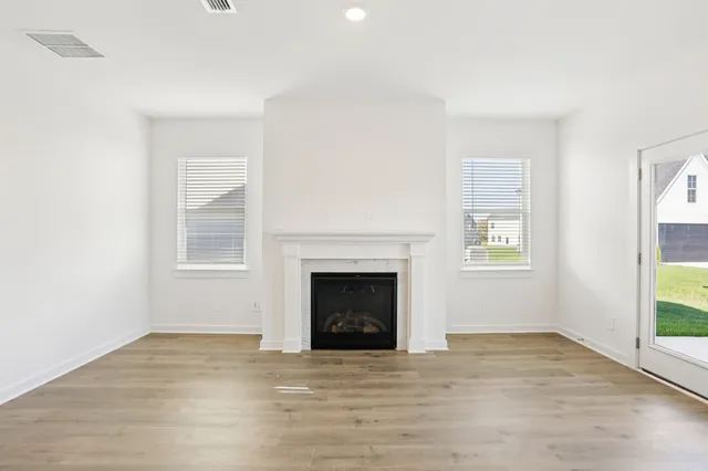 a view of empty room with wooden floor and fireplace