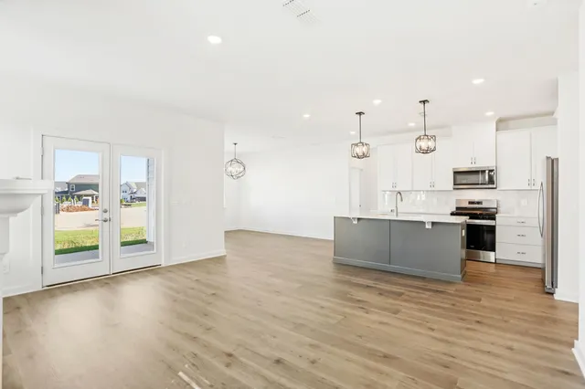 a large kitchen with stainless steel appliances kitchen island granite countertop a large counter top and a stove